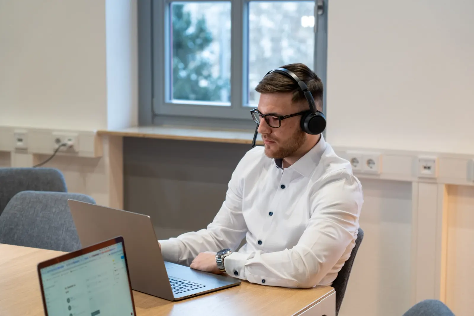 Hannes Henke mit Headset am Laptop im Kundengespräch