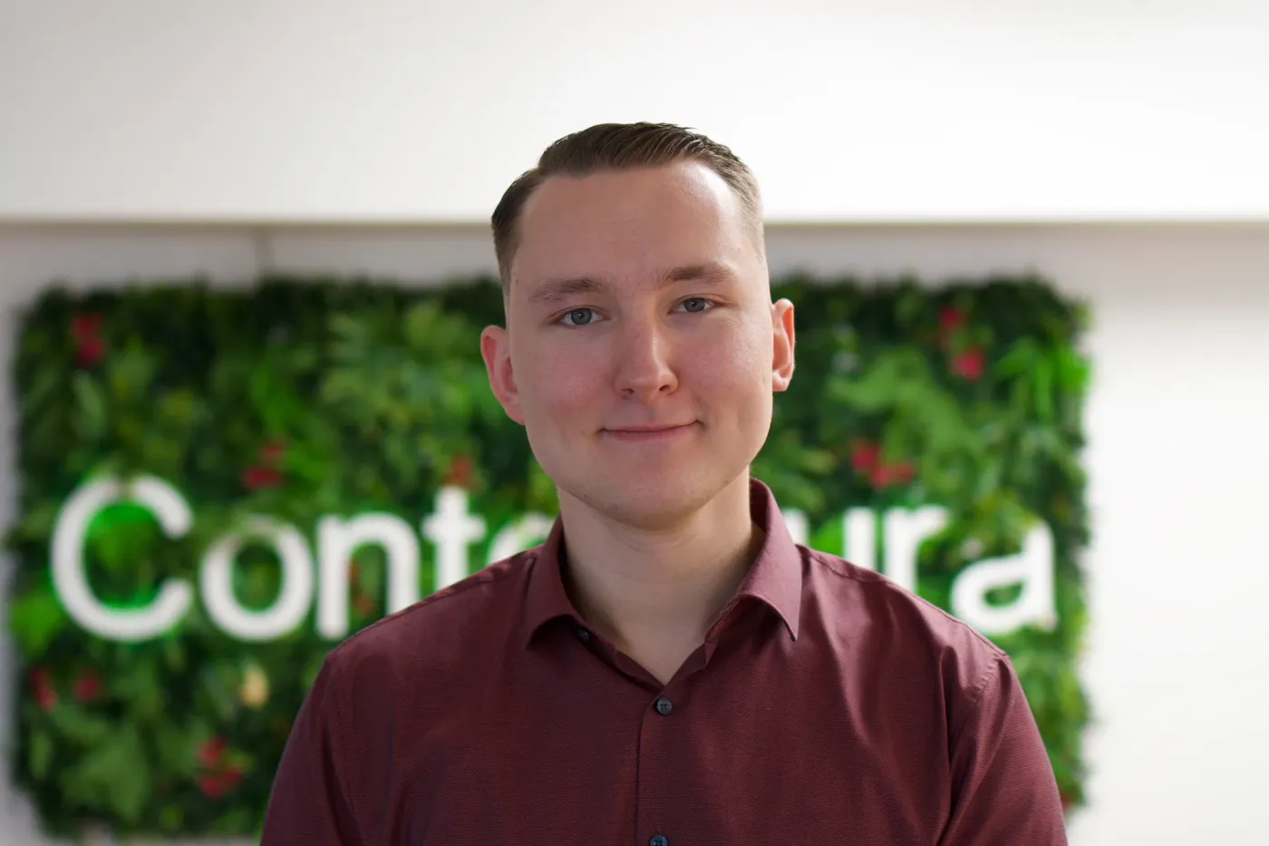 Sebastian Berndt vor der begrünten Wand mit dem Contentura-Schriftzug